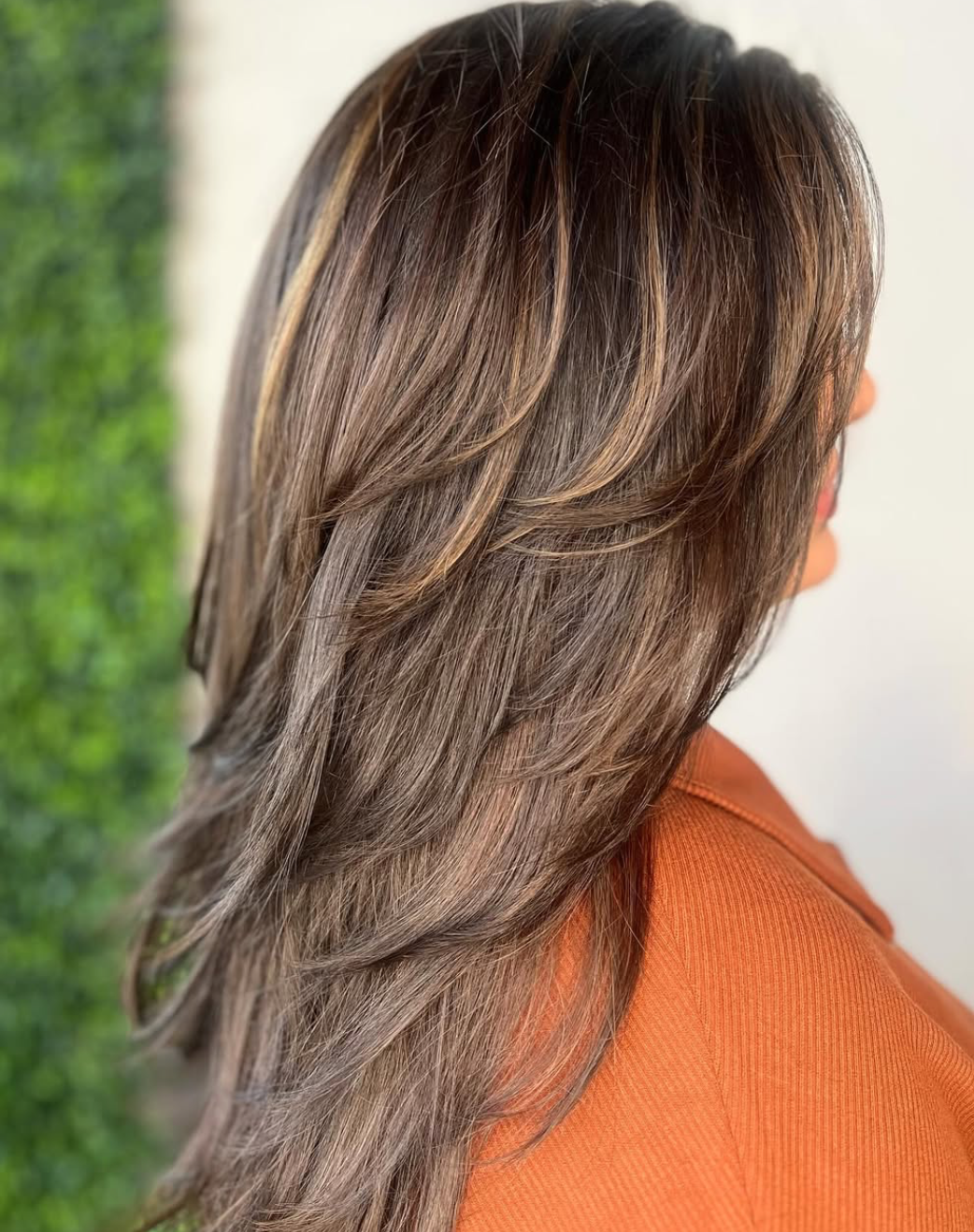 Long layered brunette cut with caramel highlights