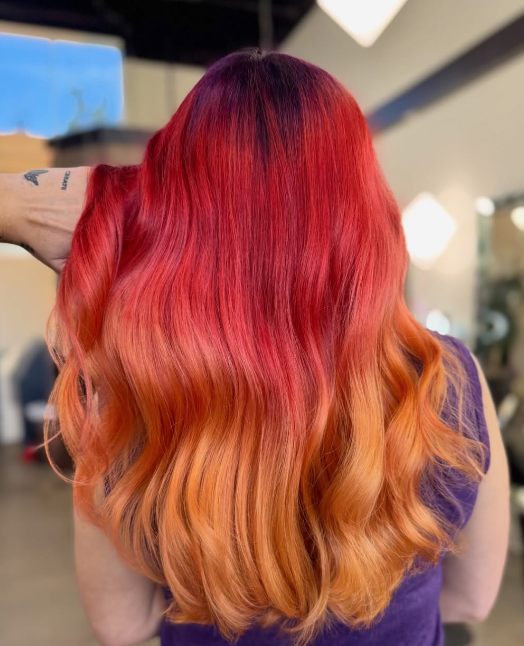 Vivid red-to-copper colour melt styled in glossy waves